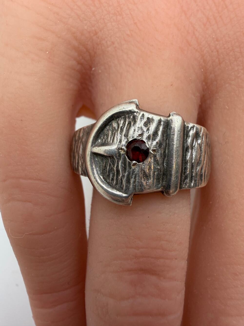 sterling silver buckle ring a faceted deep red ruby center stone. is tested